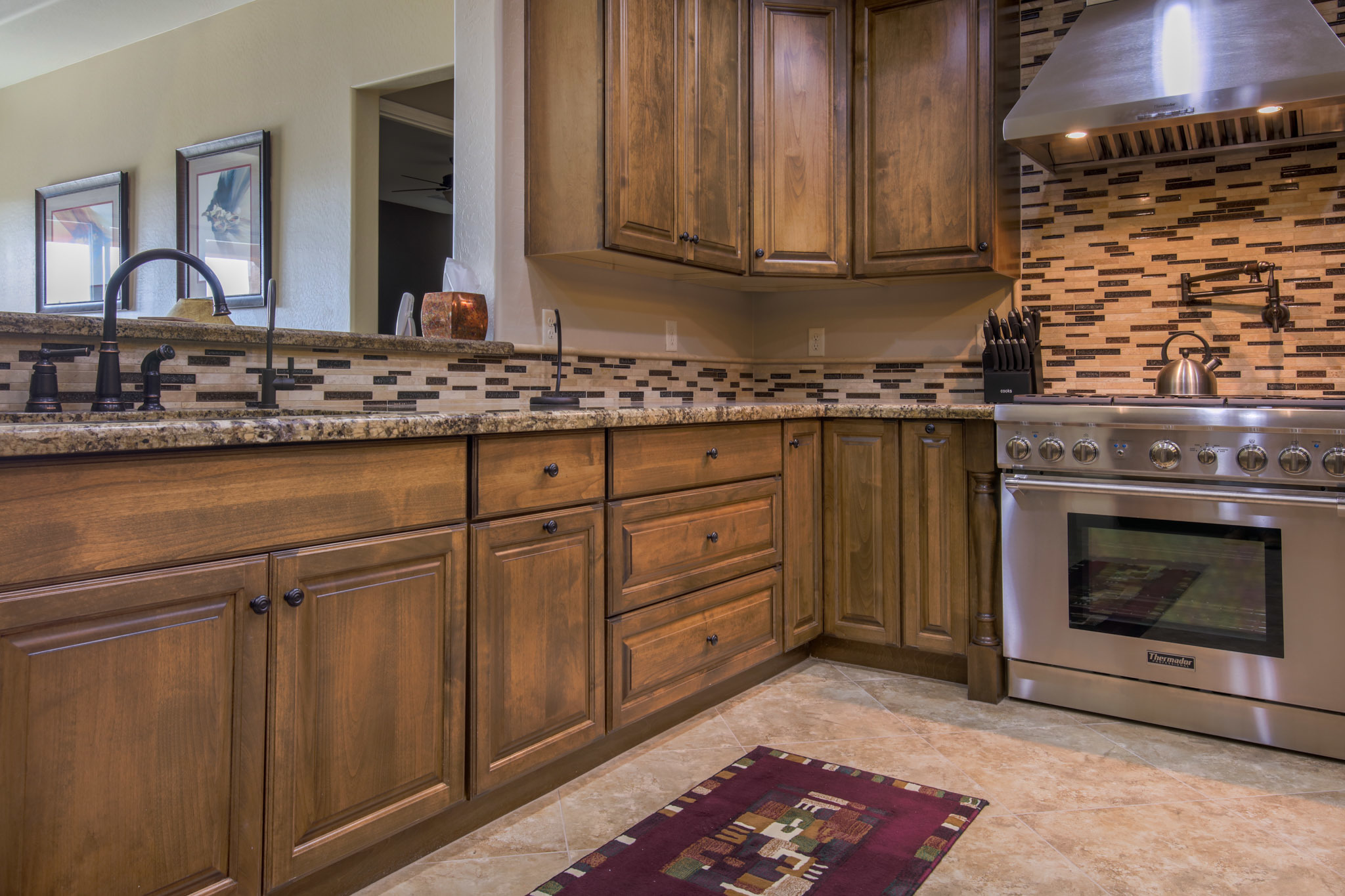 Kitchen remodel near Mesa AZ by Maverick Kitchens with stained Sollid cabinetry, mosaic backsplash, and professional-grade range